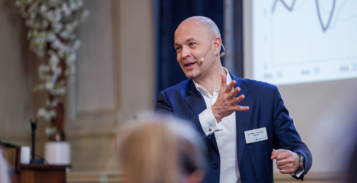 A man stands and talks with a headset microphone