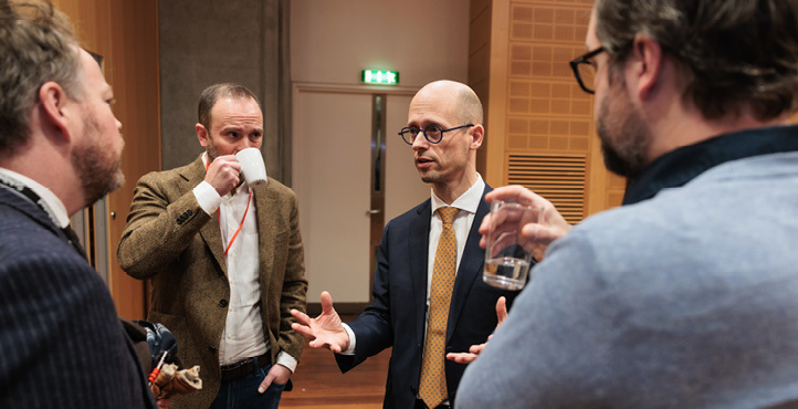 Four men standing and conversing