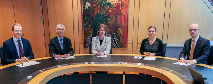 The Committee sitting at a meeting table
