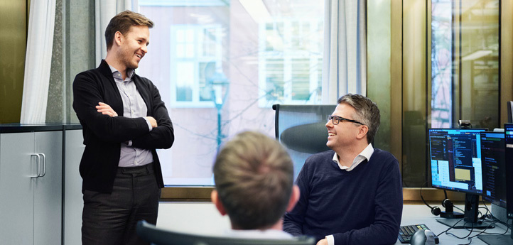 Three men in conversation at a table