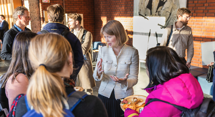 Ida Wolden Bache standing conversing with students